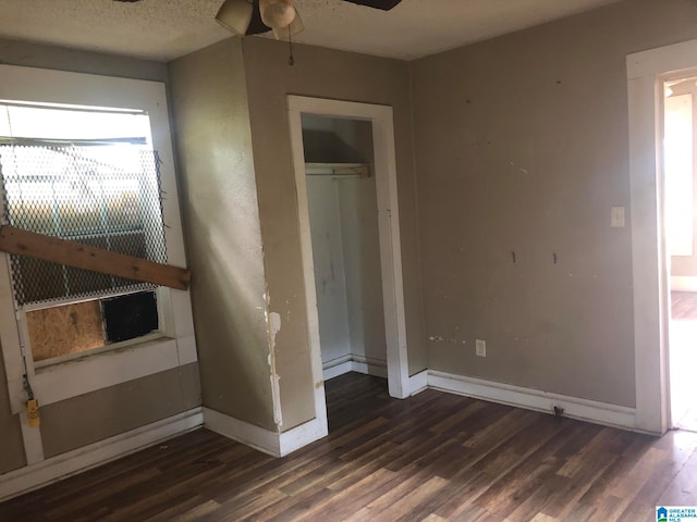 unfurnished bedroom featuring a textured ceiling, a closet, and dark hardwood / wood-style flooring