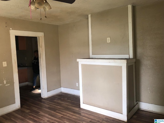 spare room featuring ceiling fan, a textured ceiling, and dark wood-type flooring