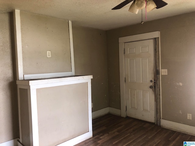 foyer entrance with a textured ceiling, dark hardwood / wood-style floors, and ceiling fan