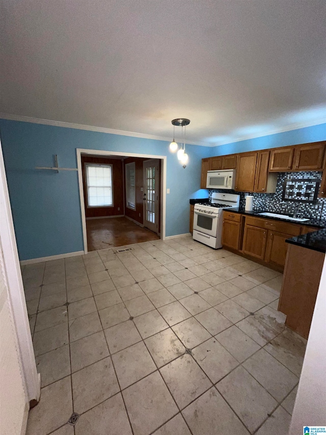 kitchen featuring light tile patterned flooring, tasteful backsplash, white appliances, decorative light fixtures, and ornamental molding