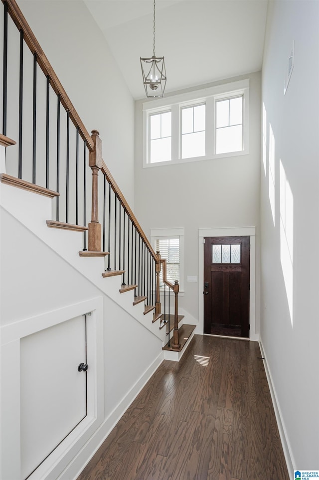 entrance foyer with a notable chandelier, a high ceiling, and dark hardwood / wood-style floors