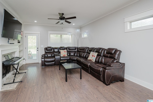 living room with wood-type flooring, crown molding, and ceiling fan