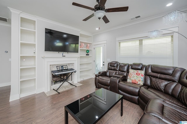 living room with ceiling fan, a fireplace, hardwood / wood-style floors, and crown molding