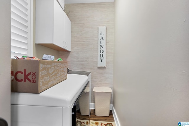 laundry room with washer and clothes dryer, cabinets, and hardwood / wood-style flooring