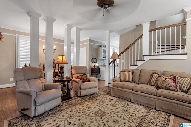 living room with ornate columns, wood-type flooring, ceiling fan, and crown molding