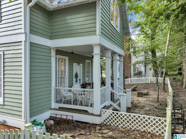 view of exterior entry featuring ceiling fan and covered porch