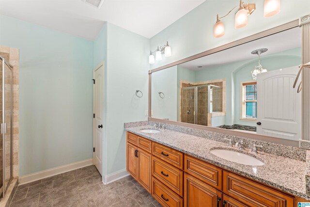 bathroom featuring tile patterned floors, a chandelier, a shower with door, and vanity