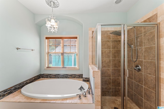 bathroom featuring an inviting chandelier and shower with separate bathtub