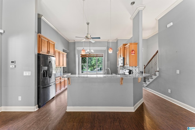 kitchen featuring appliances with stainless steel finishes, dark hardwood / wood-style floors, kitchen peninsula, and crown molding