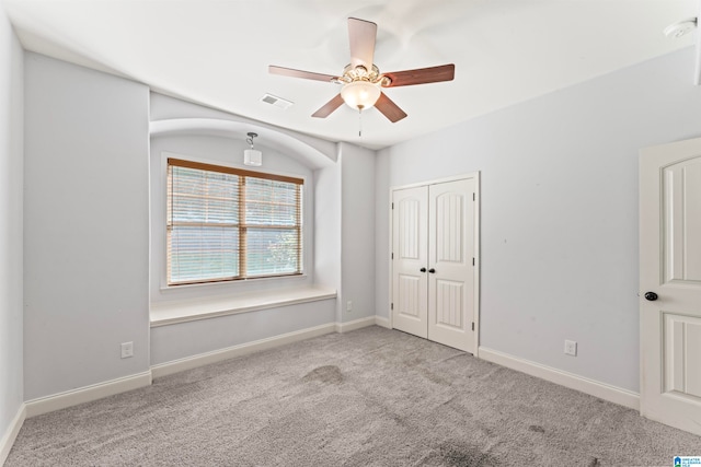 unfurnished bedroom featuring a closet, ceiling fan, and light colored carpet