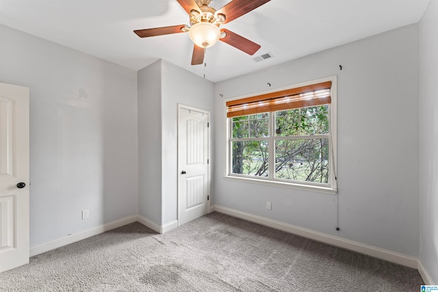 unfurnished bedroom featuring ceiling fan, light colored carpet, and a closet