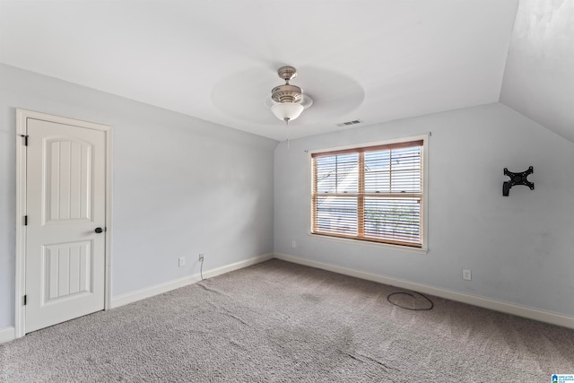 carpeted spare room featuring lofted ceiling and ceiling fan