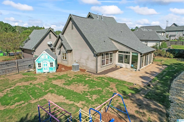 back of house with a playground, a sunroom, central air condition unit, and a patio area