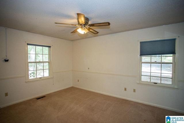 carpeted spare room featuring ceiling fan and a textured ceiling