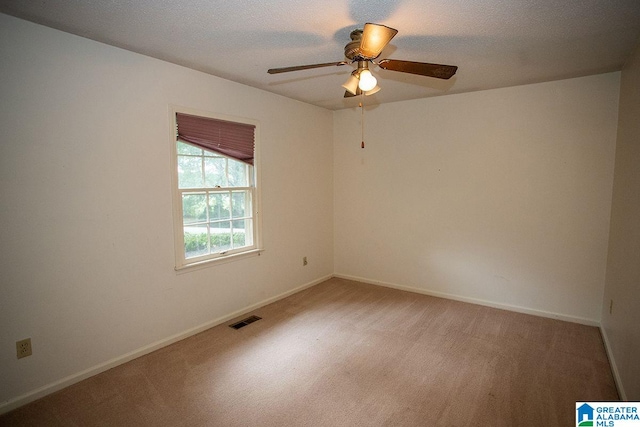 carpeted empty room with ceiling fan and a textured ceiling