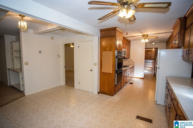 kitchen featuring appliances with stainless steel finishes, hanging light fixtures, a textured ceiling, and ceiling fan