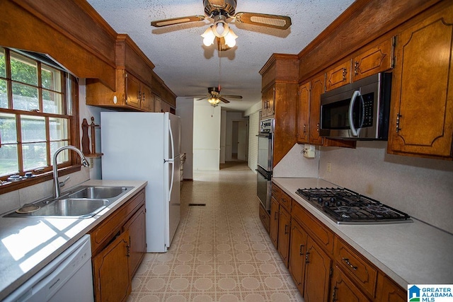 kitchen featuring ceiling fan, a textured ceiling, appliances with stainless steel finishes, and sink