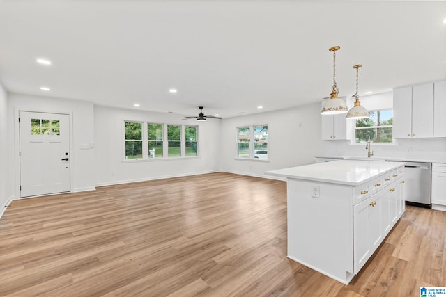 kitchen featuring a healthy amount of sunlight, a center island, dishwasher, and light hardwood / wood-style flooring