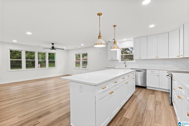 kitchen with a kitchen island, decorative light fixtures, white cabinetry, stainless steel appliances, and light hardwood / wood-style floors