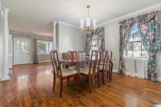 dining area with ornate columns, hardwood / wood-style flooring, ornamental molding, and a textured ceiling