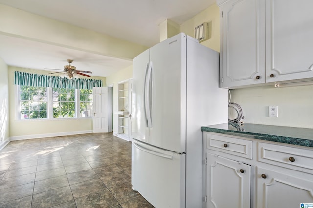 kitchen featuring white fridge, ceiling fan, white cabinetry, and dark tile patterned flooring