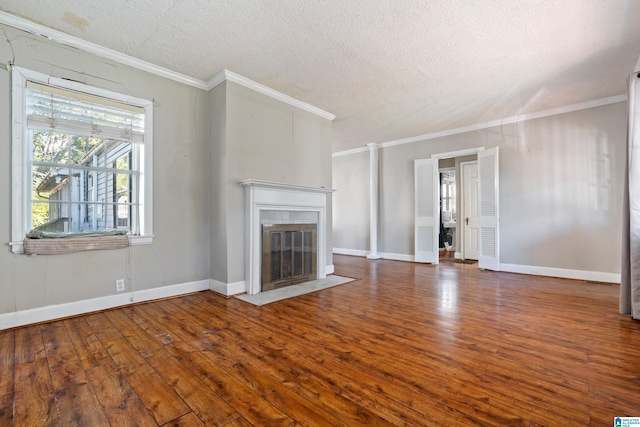 unfurnished living room with ornamental molding, a textured ceiling, a tile fireplace, and dark hardwood / wood-style flooring