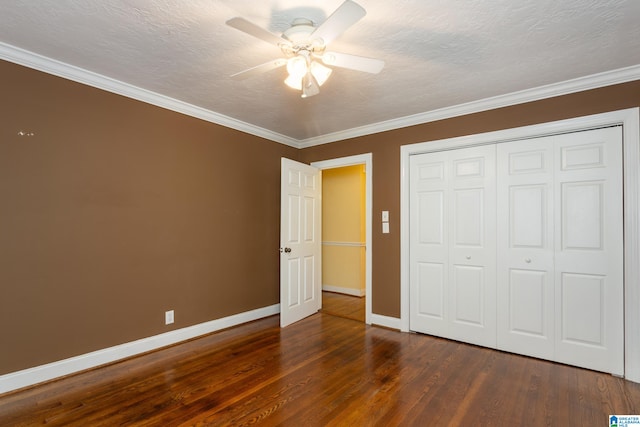 unfurnished bedroom featuring a closet, a textured ceiling, dark hardwood / wood-style flooring, ornamental molding, and ceiling fan