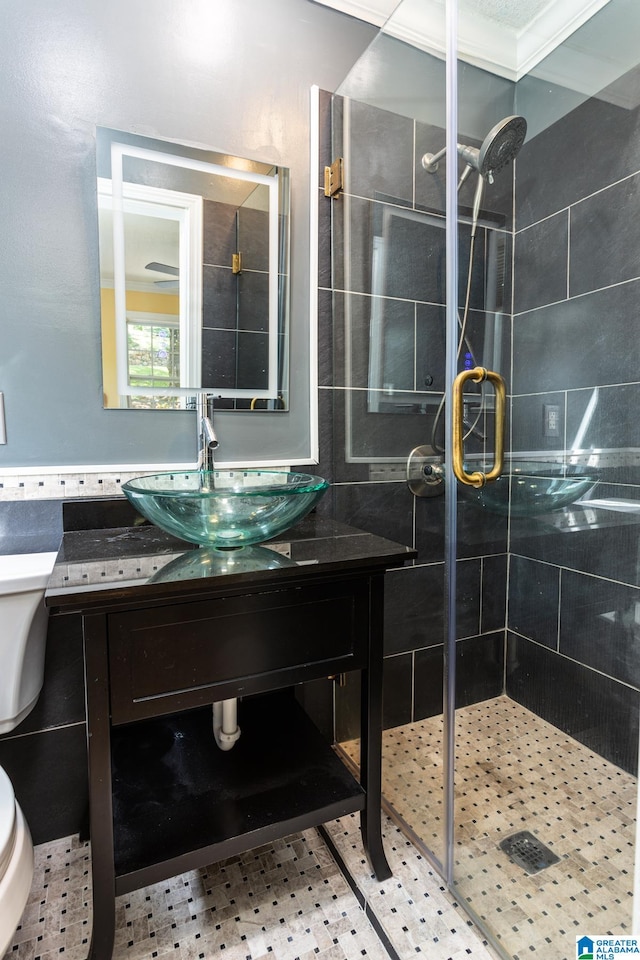 bathroom with a shower with shower door, crown molding, vanity, and toilet