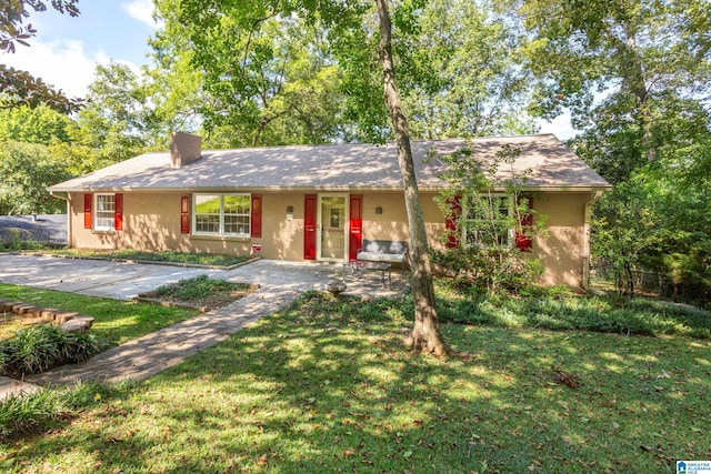 ranch-style home with a front lawn and a patio