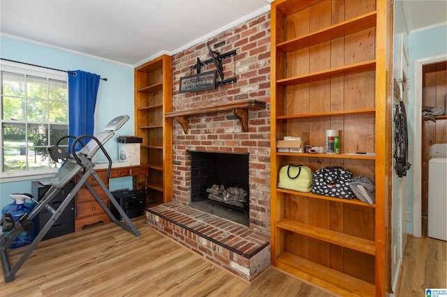 living room featuring crown molding, a fireplace, and light hardwood / wood-style flooring