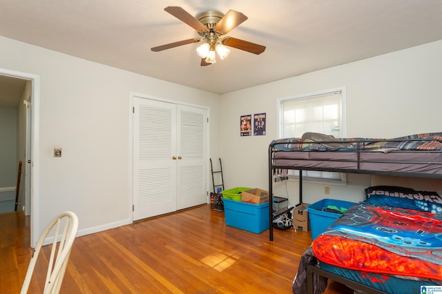 bedroom featuring ceiling fan, a closet, and hardwood / wood-style floors