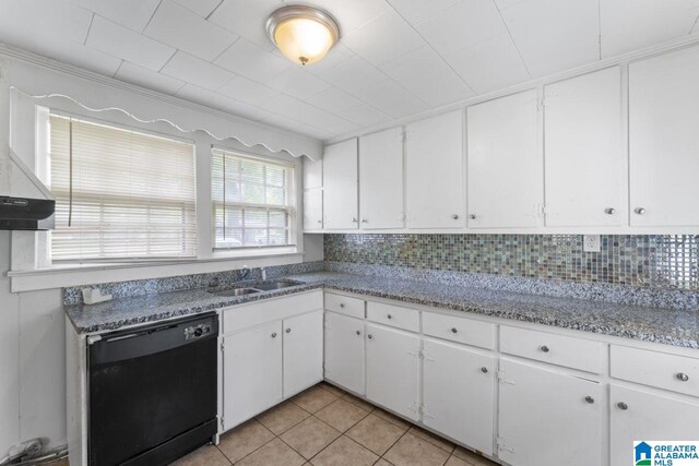 kitchen with white cabinets, black dishwasher, light tile patterned floors, and decorative backsplash