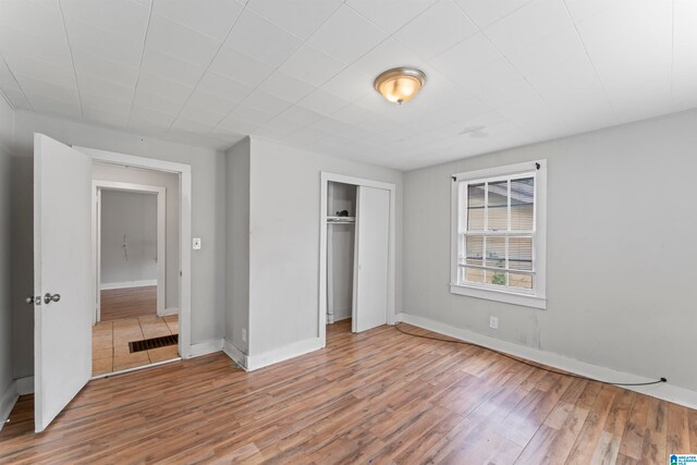 unfurnished bedroom with wood-type flooring and a closet