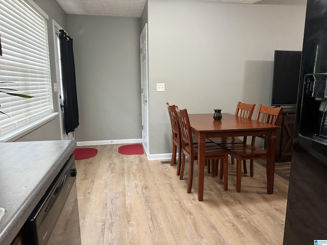 dining room featuring light hardwood / wood-style flooring and a textured ceiling