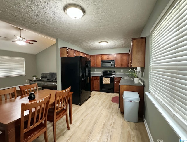 kitchen with ceiling fan, sink, a textured ceiling, black appliances, and light hardwood / wood-style floors