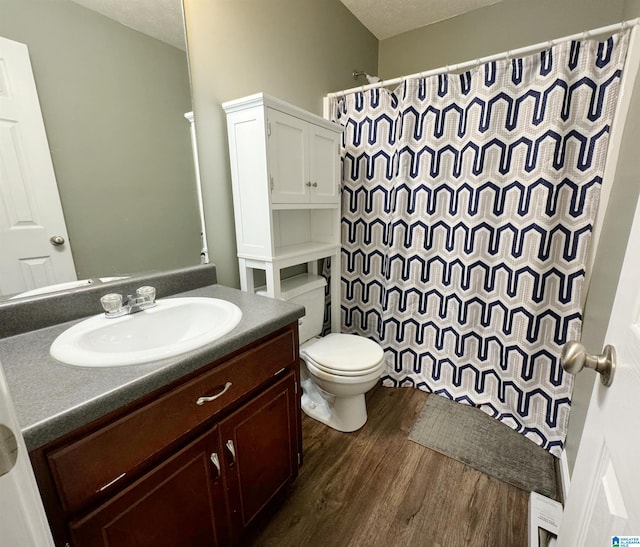 bathroom with vanity, a textured ceiling, hardwood / wood-style floors, toilet, and a shower with curtain