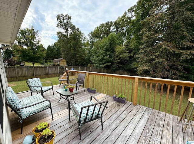 deck featuring a storage shed and a yard