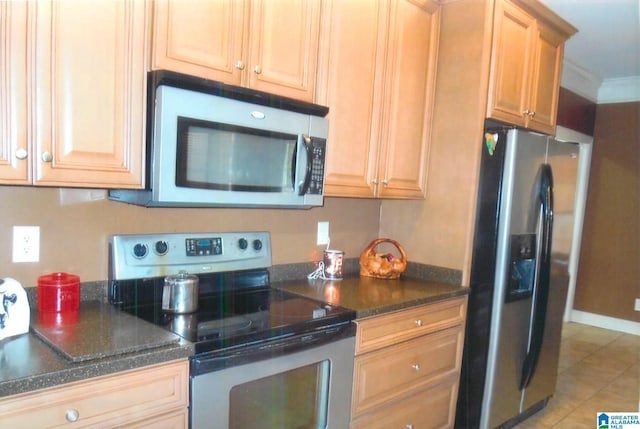 kitchen featuring light tile patterned floors, stainless steel appliances, and ornamental molding