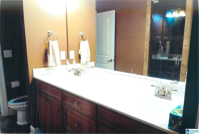 bathroom featuring vanity, toilet, and tiled shower