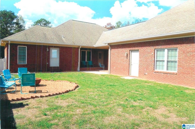 rear view of house featuring a yard and a patio area