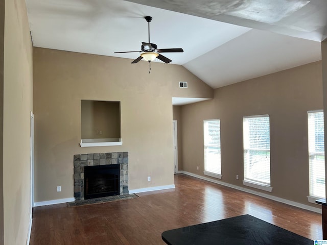 unfurnished living room featuring vaulted ceiling, ceiling fan, hardwood / wood-style flooring, and a stone fireplace