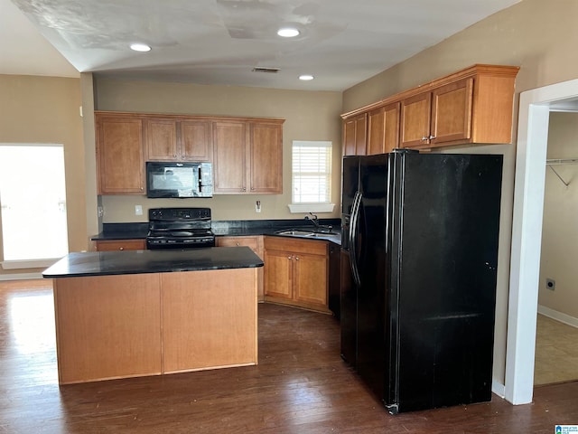 kitchen featuring dark hardwood / wood-style floors, black appliances, a center island, and sink