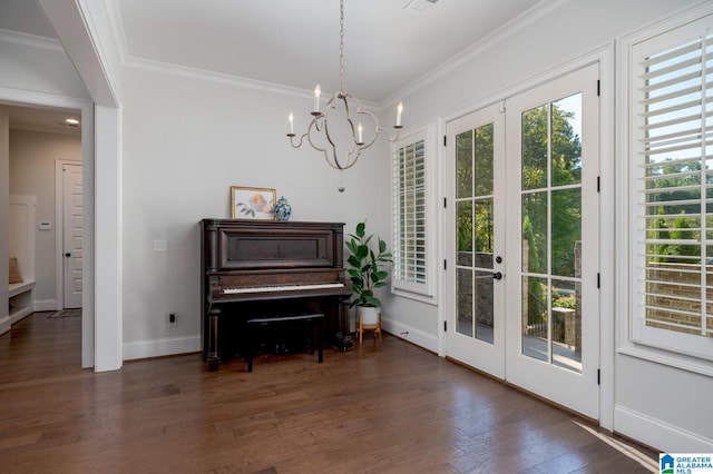 interior space with dark hardwood / wood-style floors, french doors, ornamental molding, and an inviting chandelier