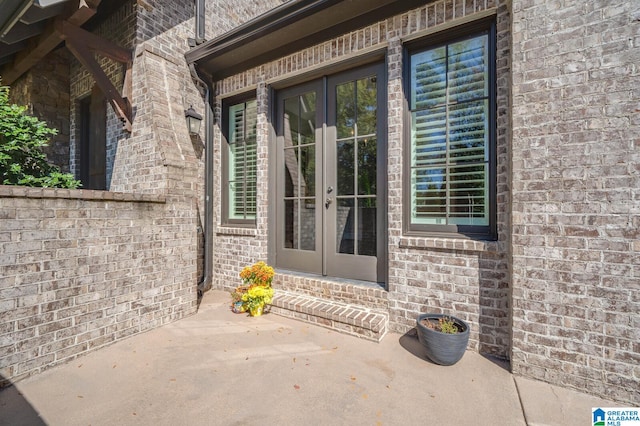 view of exterior entry featuring french doors and a patio