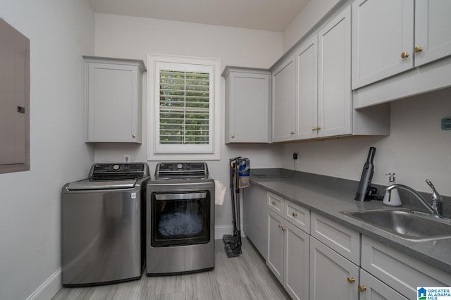 laundry room with cabinets, independent washer and dryer, sink, and electric panel