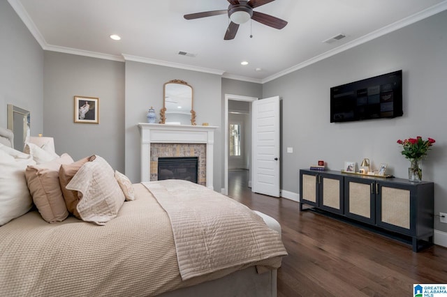 bedroom with a fireplace, ceiling fan, crown molding, and dark wood-type flooring