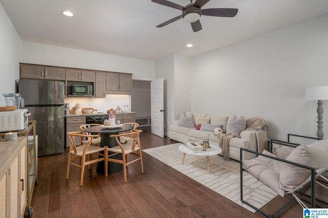 living room featuring ceiling fan and dark wood-type flooring