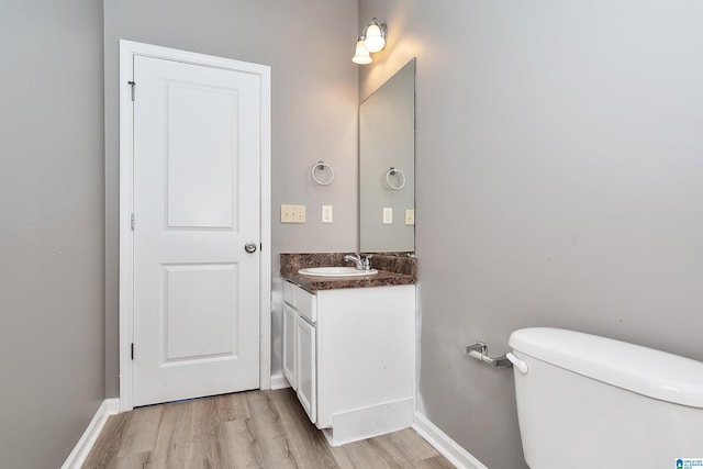 bathroom with vanity, toilet, and hardwood / wood-style flooring