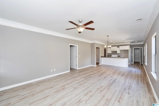 unfurnished living room featuring ceiling fan with notable chandelier, light hardwood / wood-style floors, and crown molding