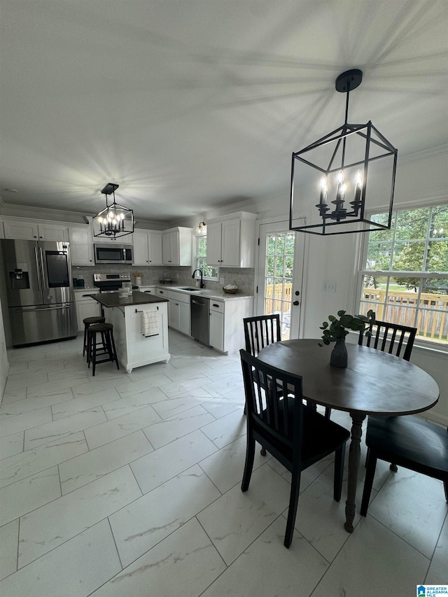 dining room featuring a notable chandelier, plenty of natural light, and sink